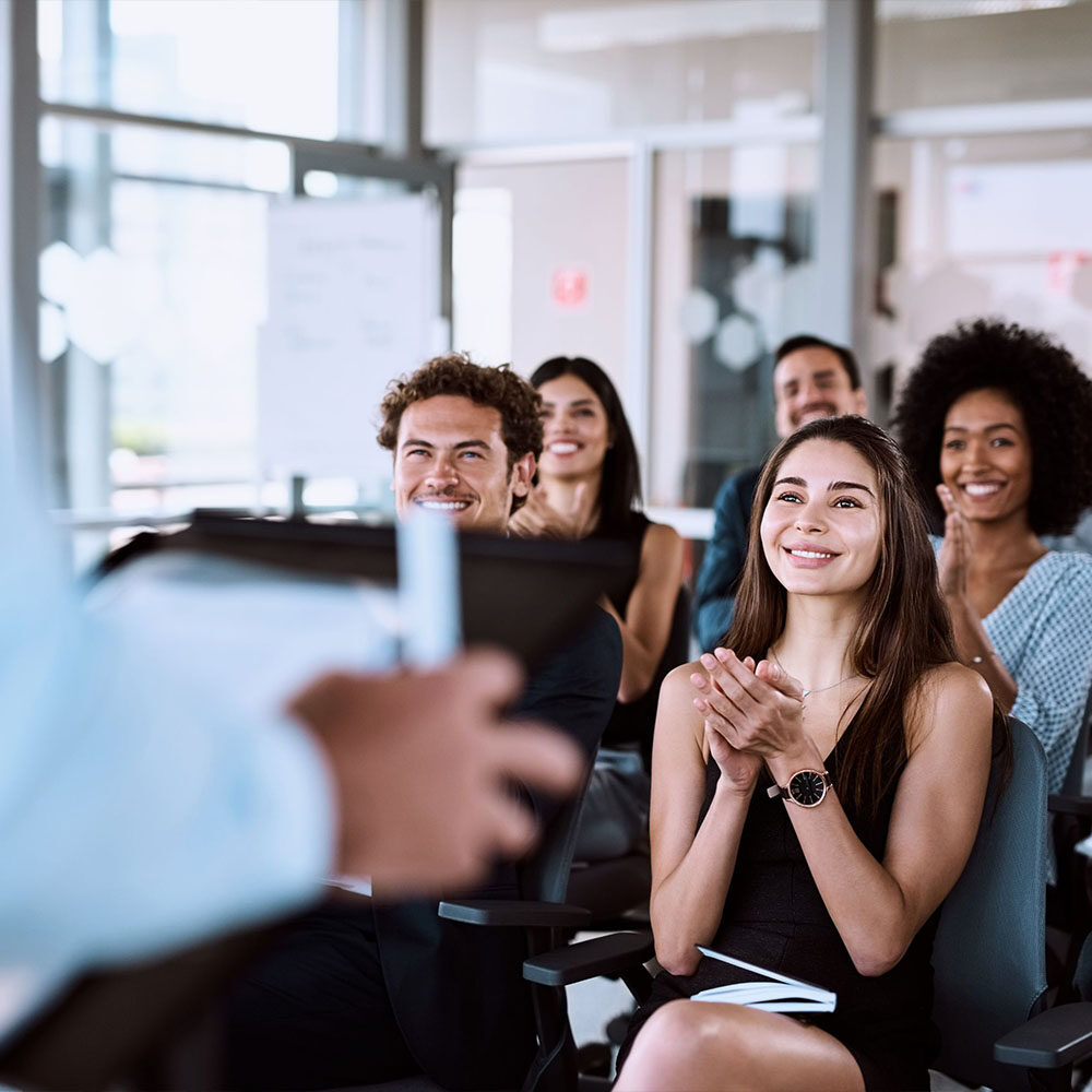 group of happy people clapping in a presentation