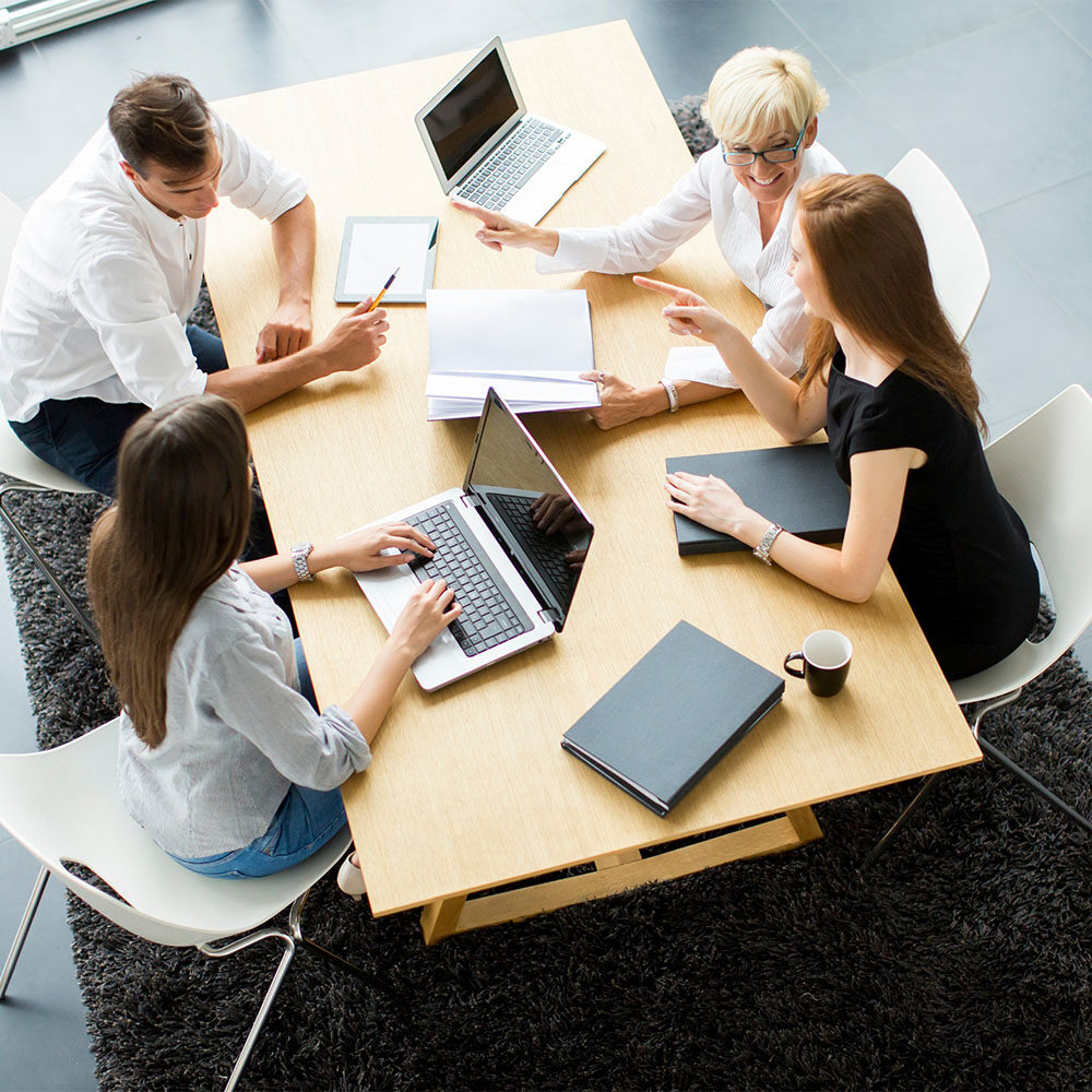 team of employees working together with laptops